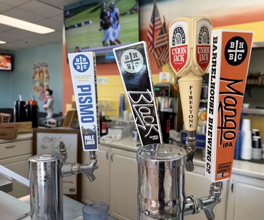 The tap tower at the bar, with a football game playing on the screen mounted above it.